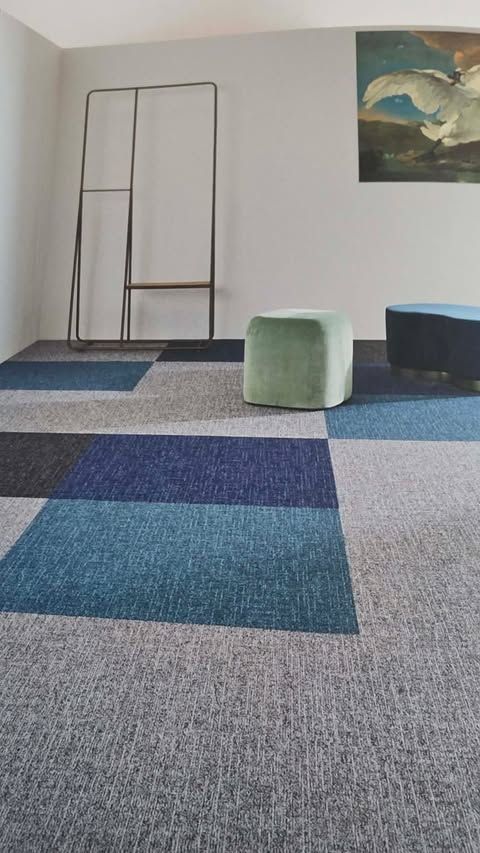 Teppichfliesen in Grau- und Blautönen als Schachbrettmuster verlegt